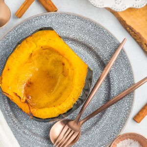 a half of acorn squash on a grey plate.