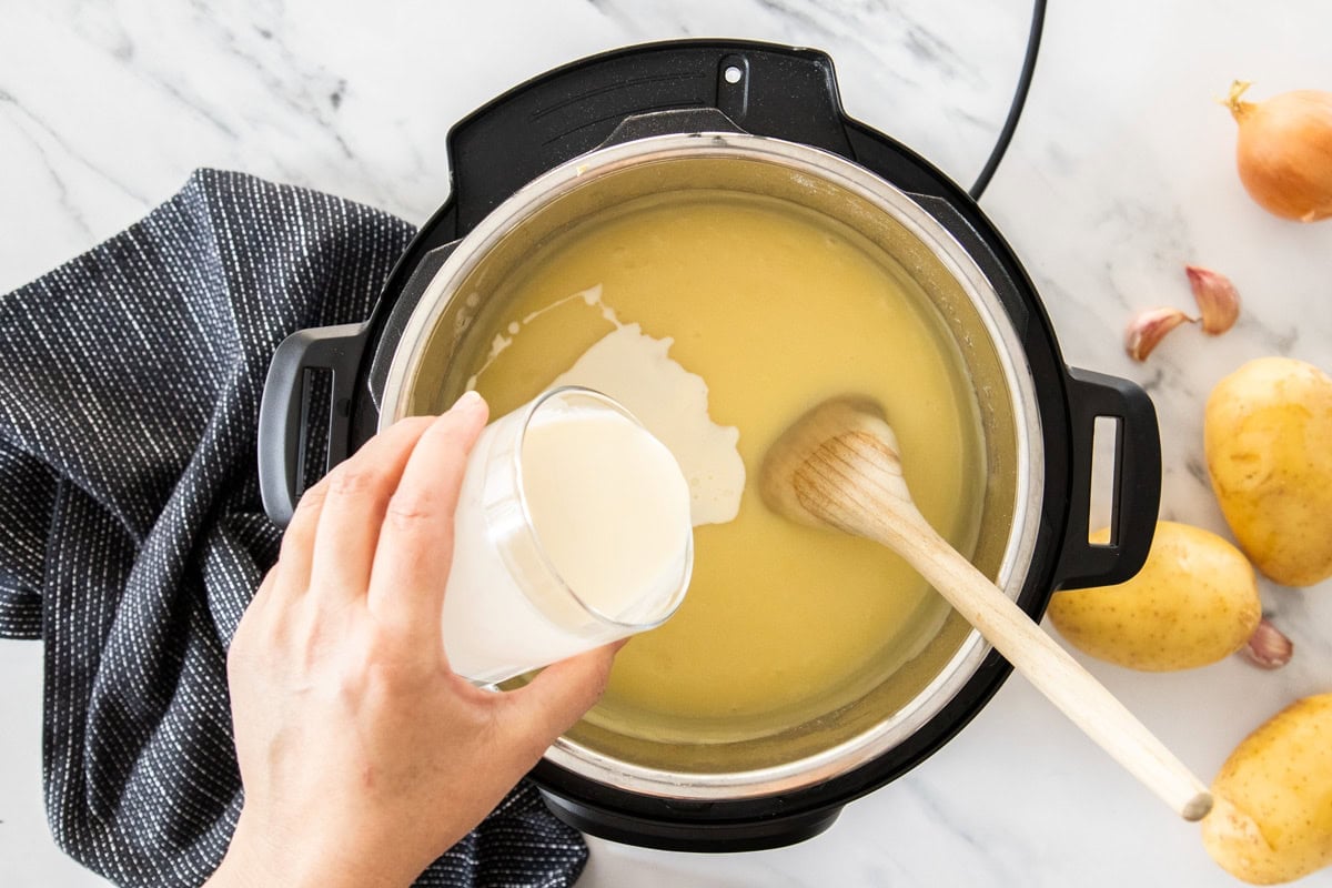 heavy cream being poured into an Instant Pot.