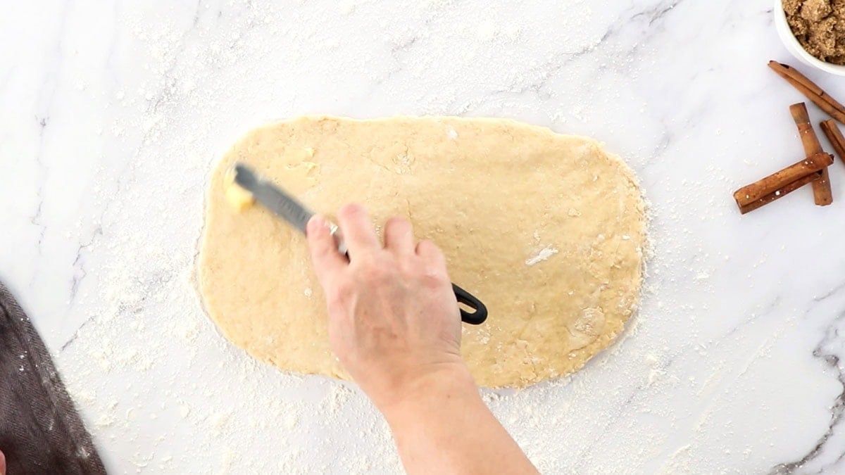 butter being spread on dough.