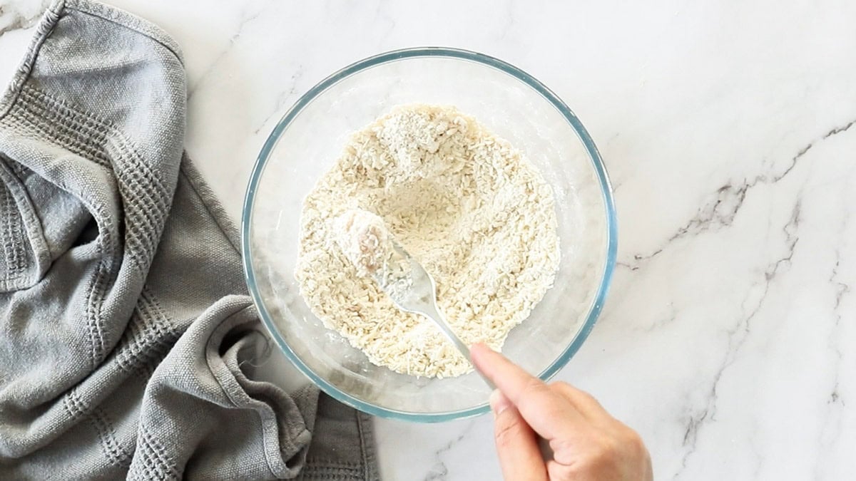 a glass bowl of panko and other breading ingredients.