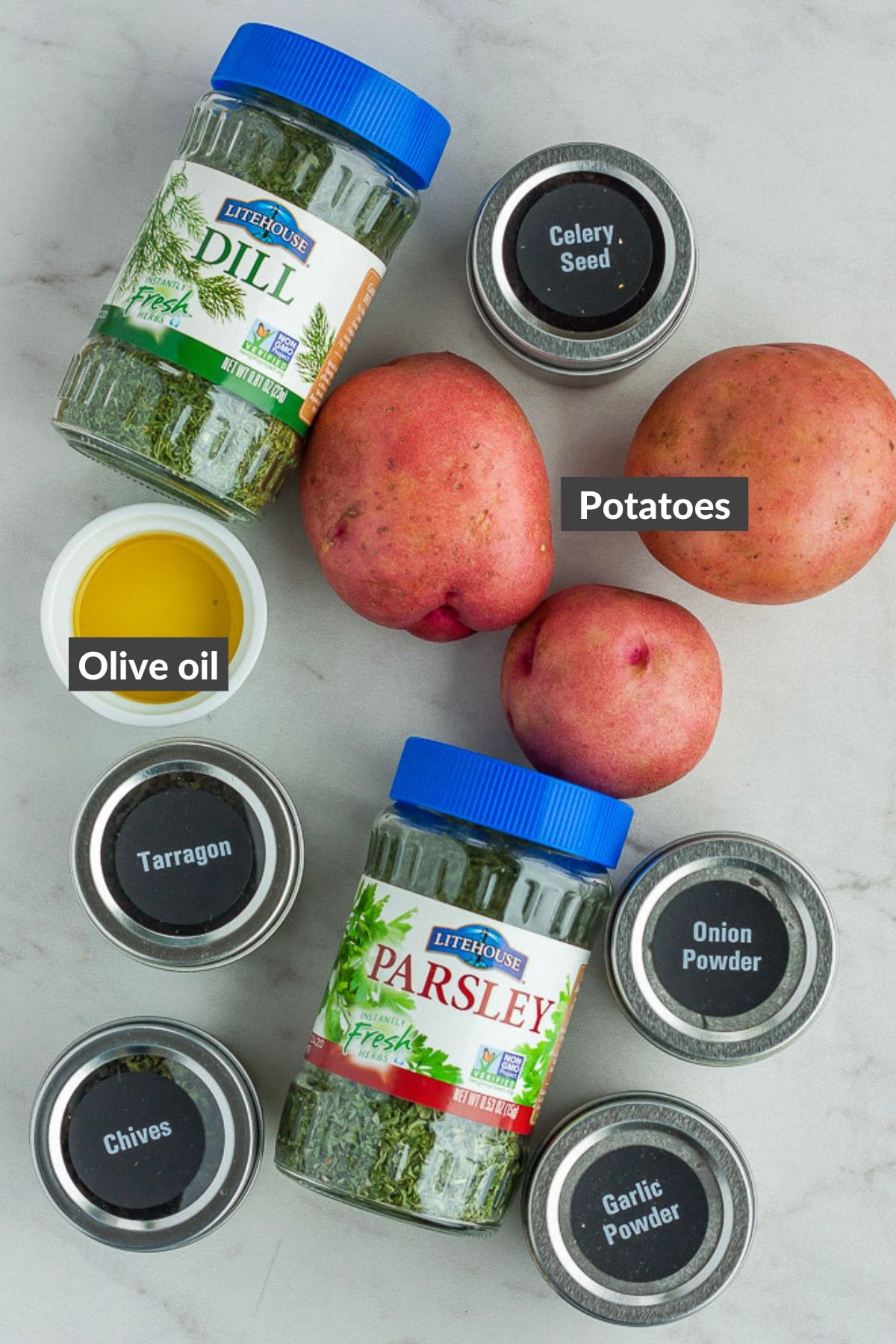 potatoes, olive oil, and spices on a grey board.