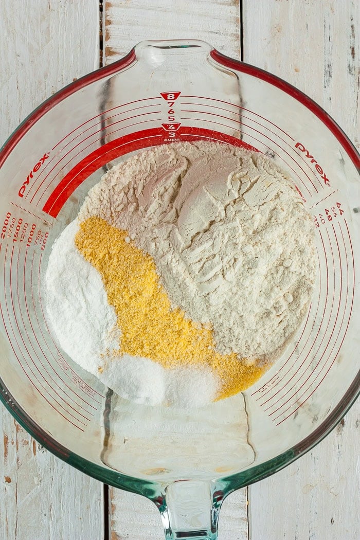 dry ingredients like flour and cornmeal in a glass bowl.