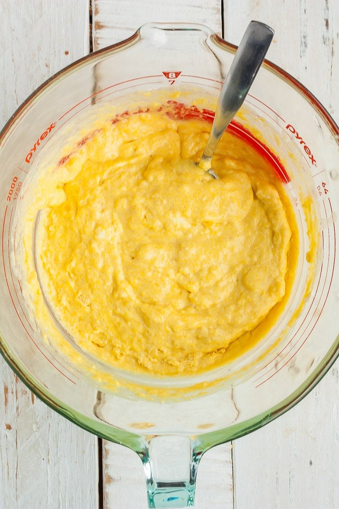 batter in a glass mixing bowl with a spoon.