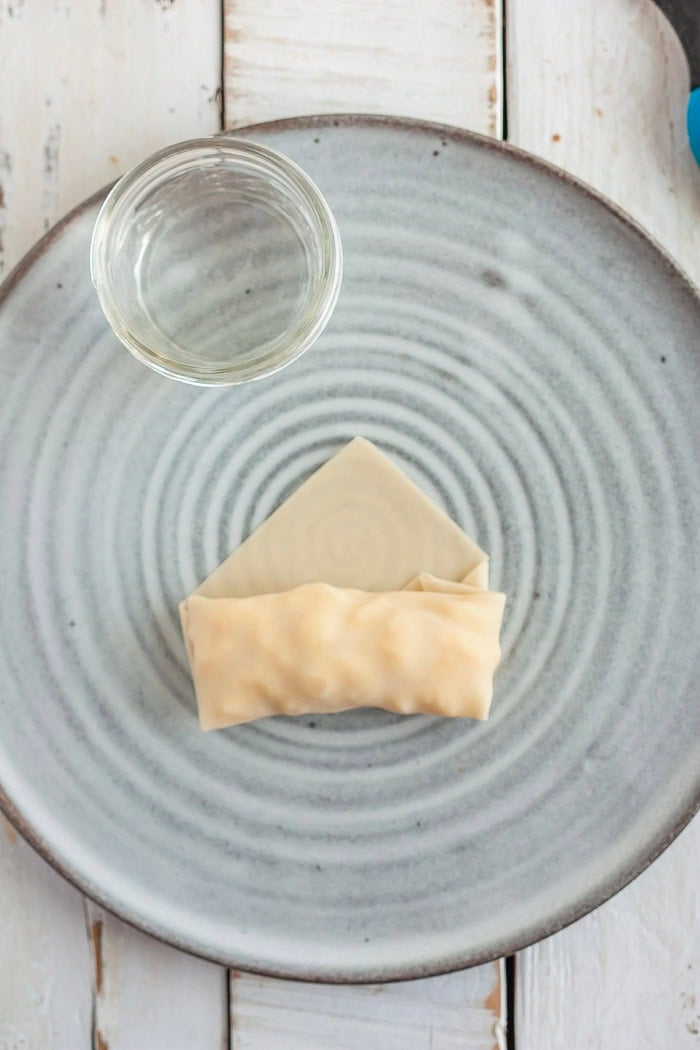 the process of showing how to fold an egg roll.