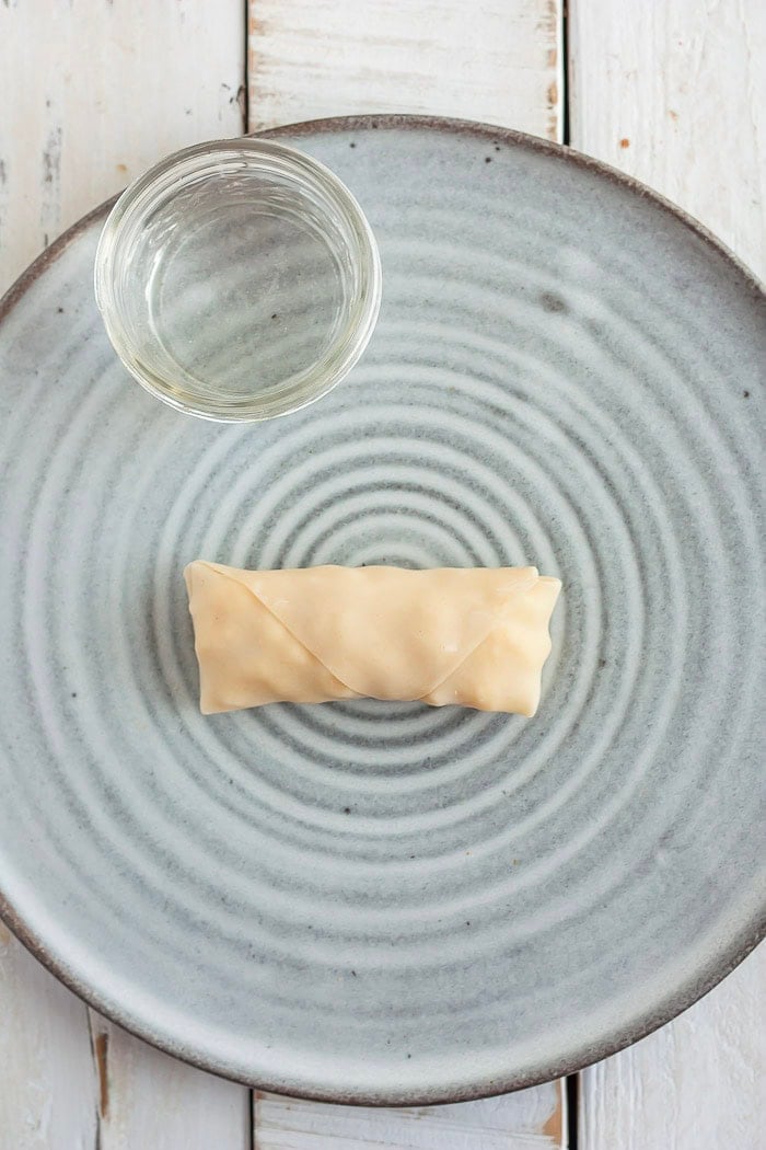 the process of showing how to fold an egg roll.