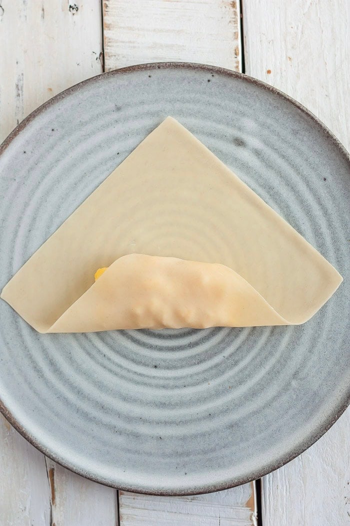 the process of showing how to fold an egg roll.