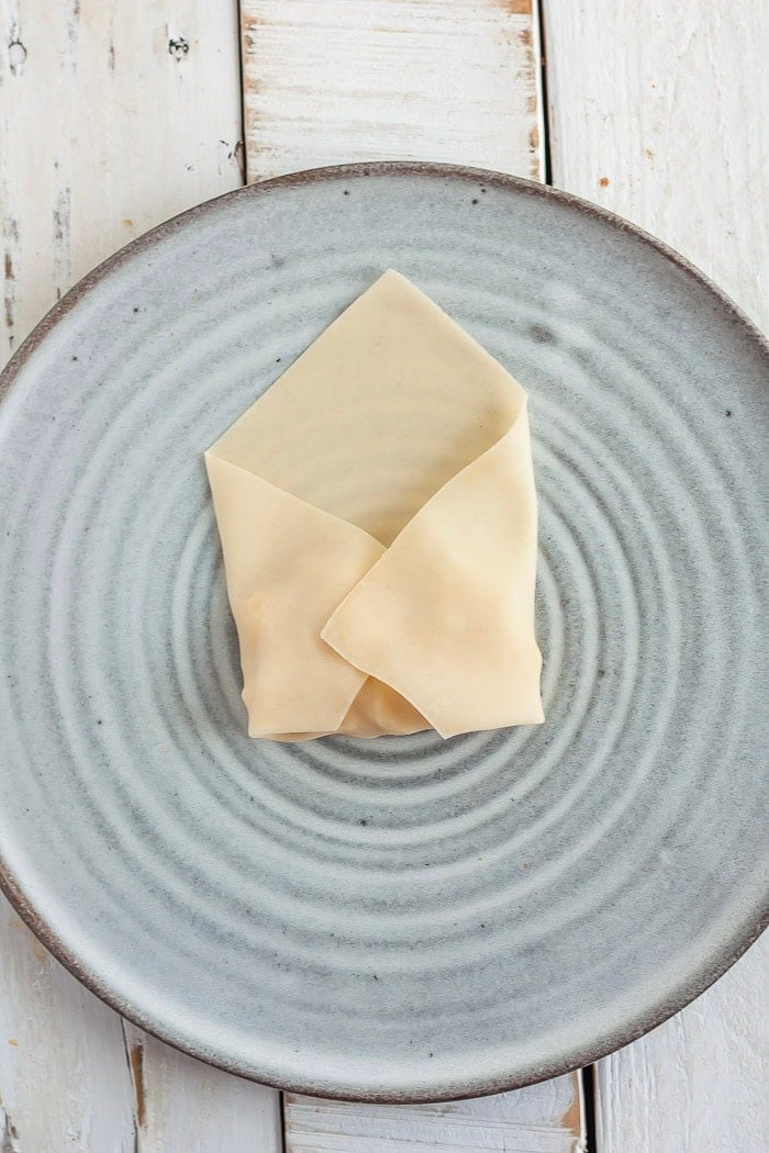 the process of showing how to fold an egg roll.