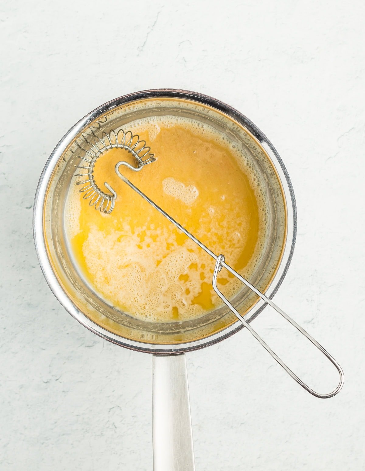a whisk in a saucepan of melted butter.