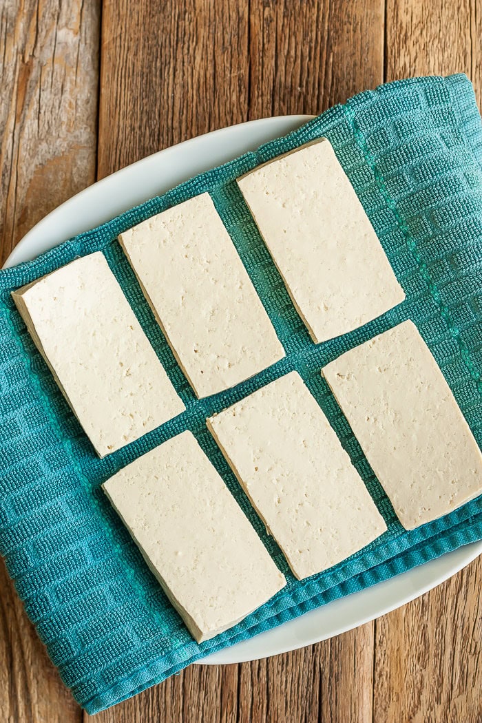 6 slices of tofu on a turquoise towel on a plate.