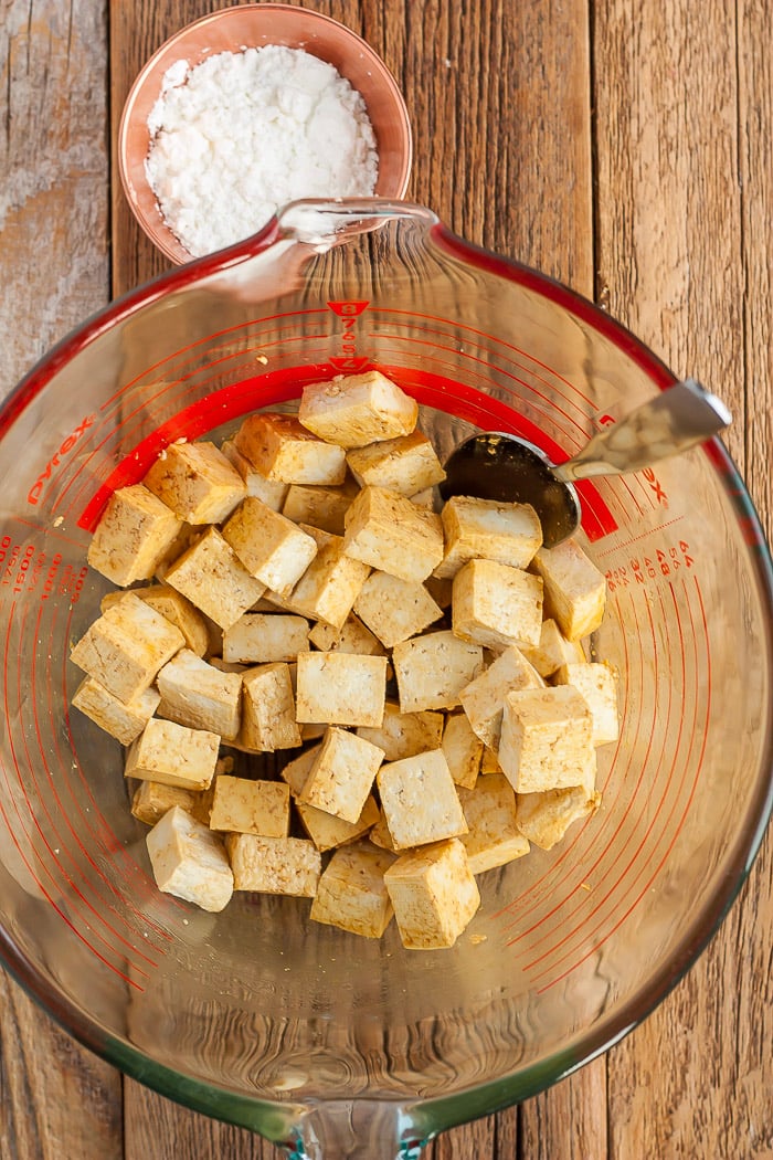 cubed tofu in a glass bowl with a spoon in it.