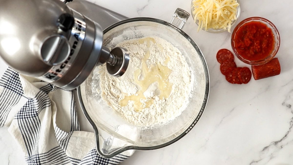 pizza dough being made in a stand mixer.