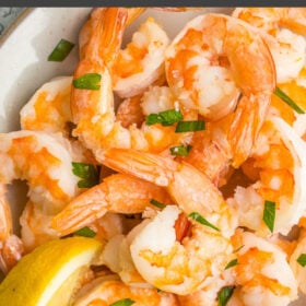 cooked air fryer shrimp on a grey plate topped with chopped parsley.