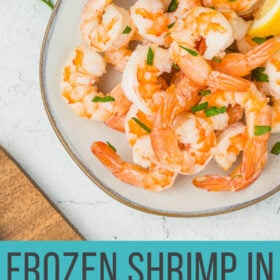 cooked air fryer shrimp on a grey plate topped with chopped parsley.