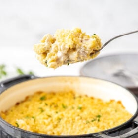 a spoon holding a scoop of chicken and broccoli casserole.