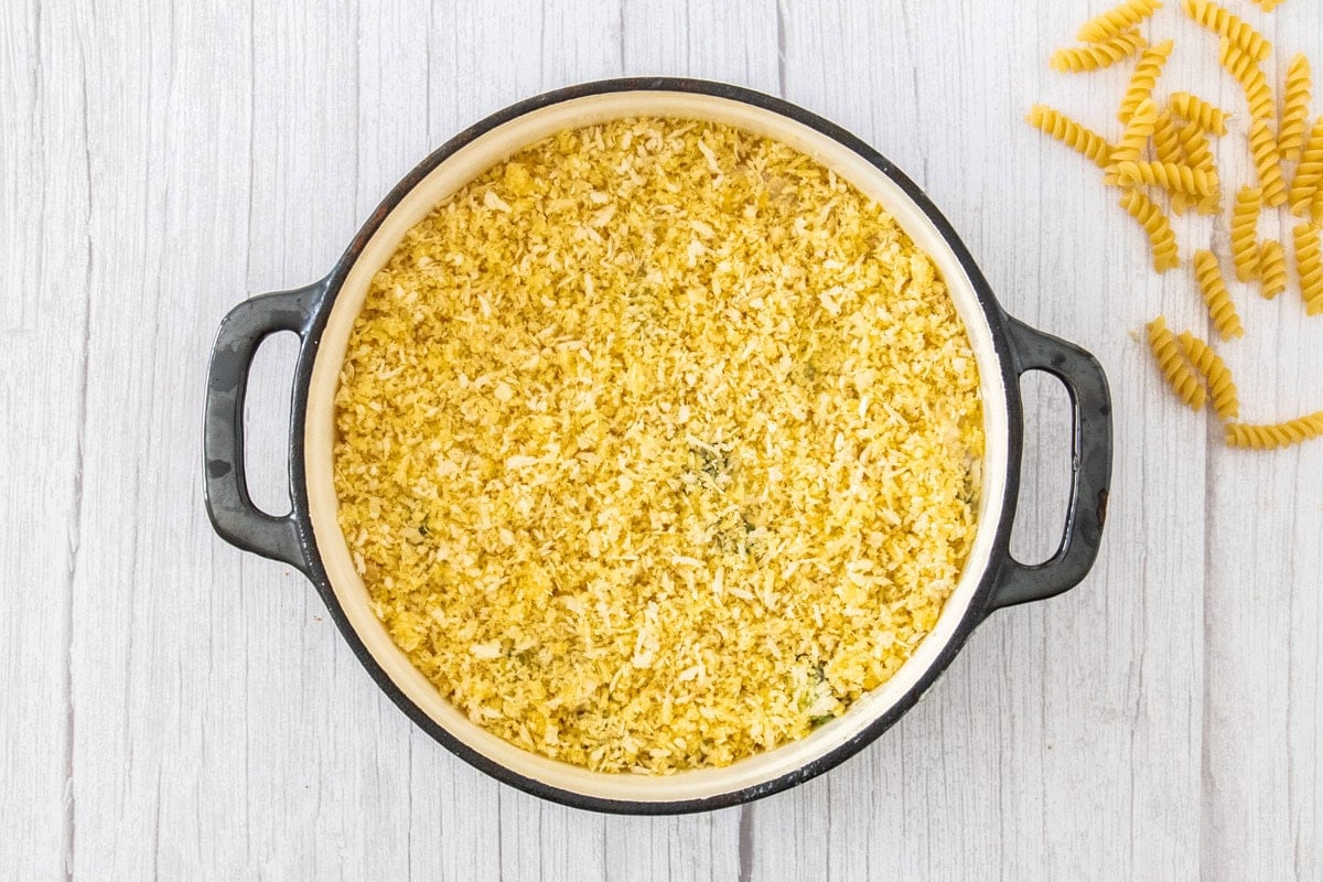 a Dutch oven with a casserole topped with bread crumbs.