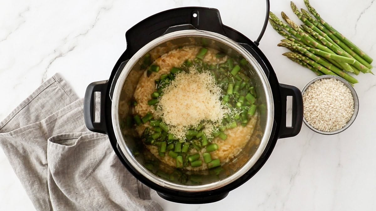 cheese on top of asparagus in a pressure cooker.