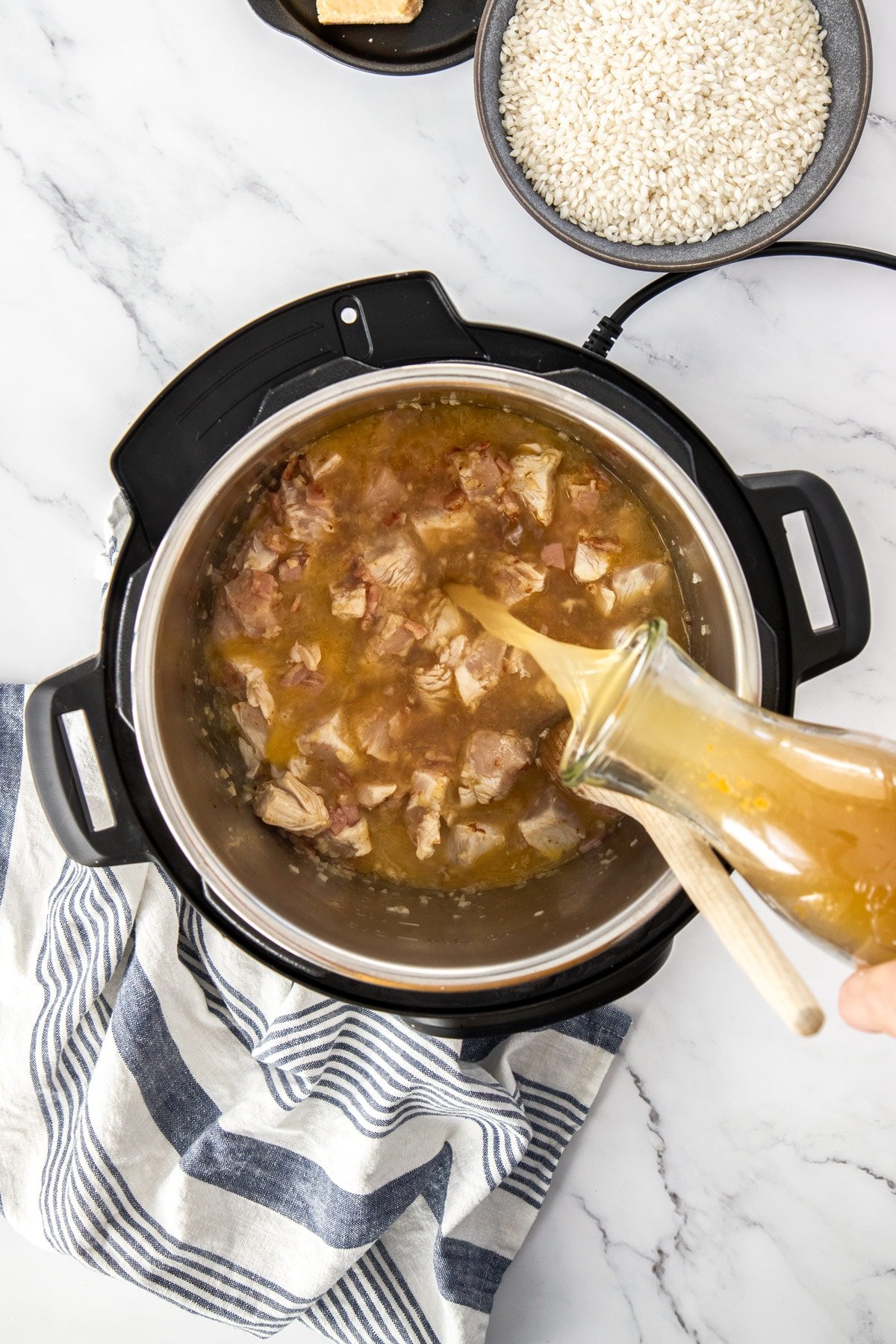 broth being poured into a pressure cooker.