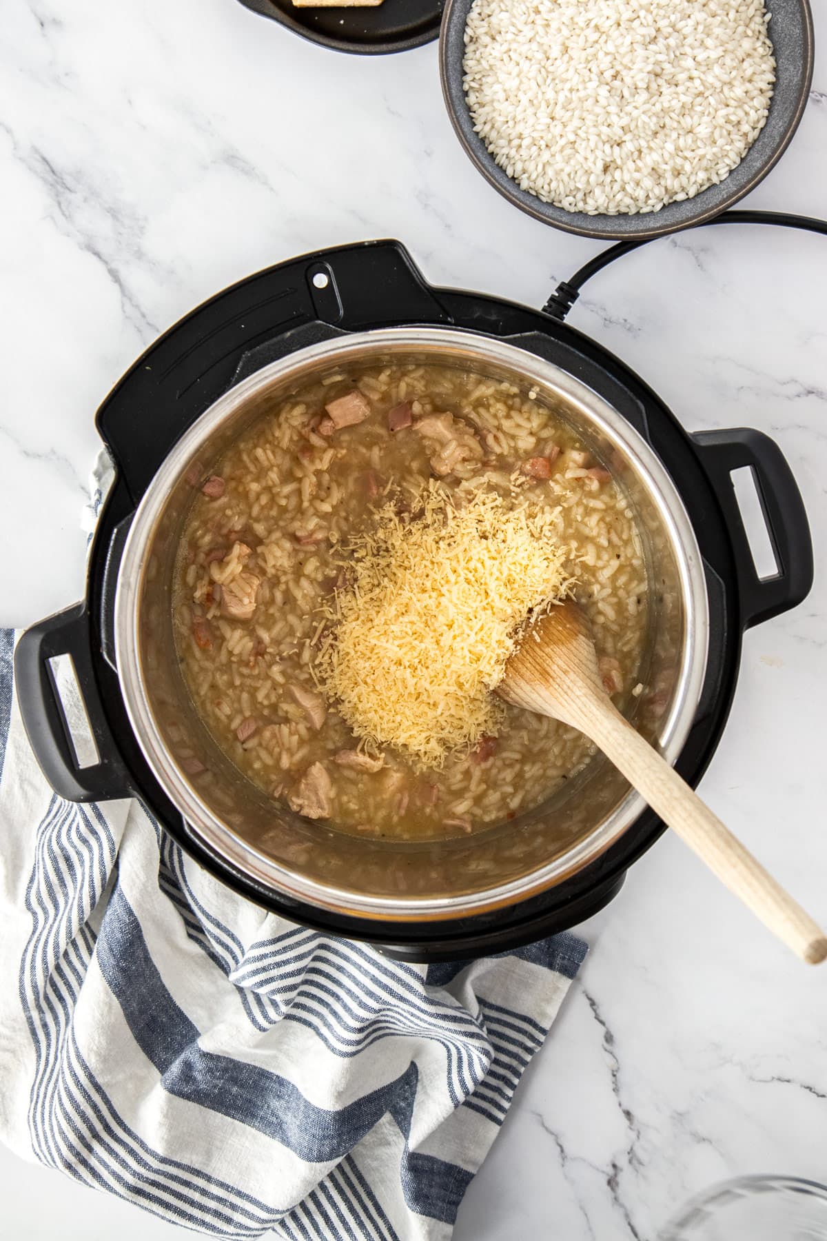 cheese being stirred into instant pot chicken bacon risotto.
