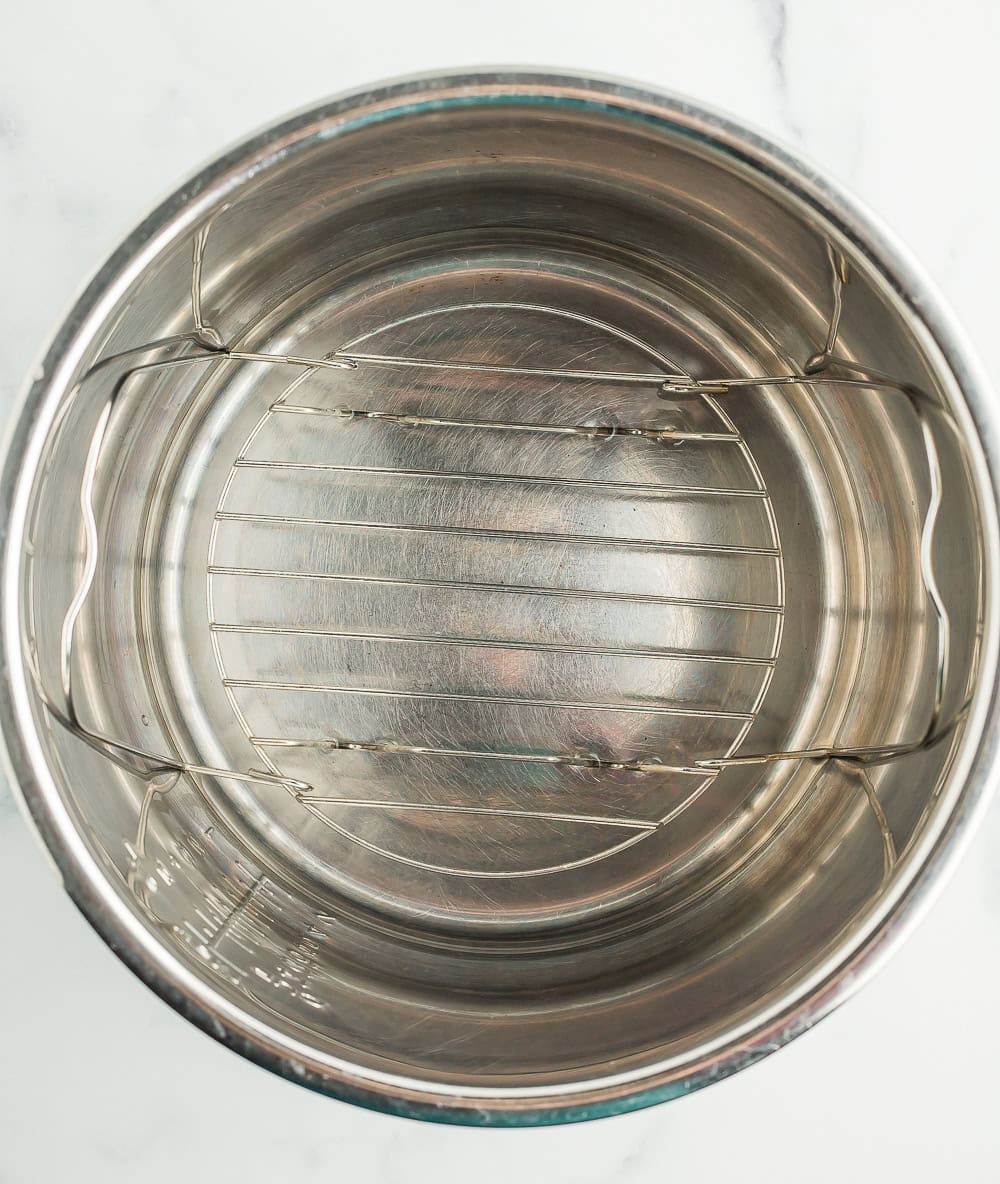a rack in a pressure cooker insert with water.