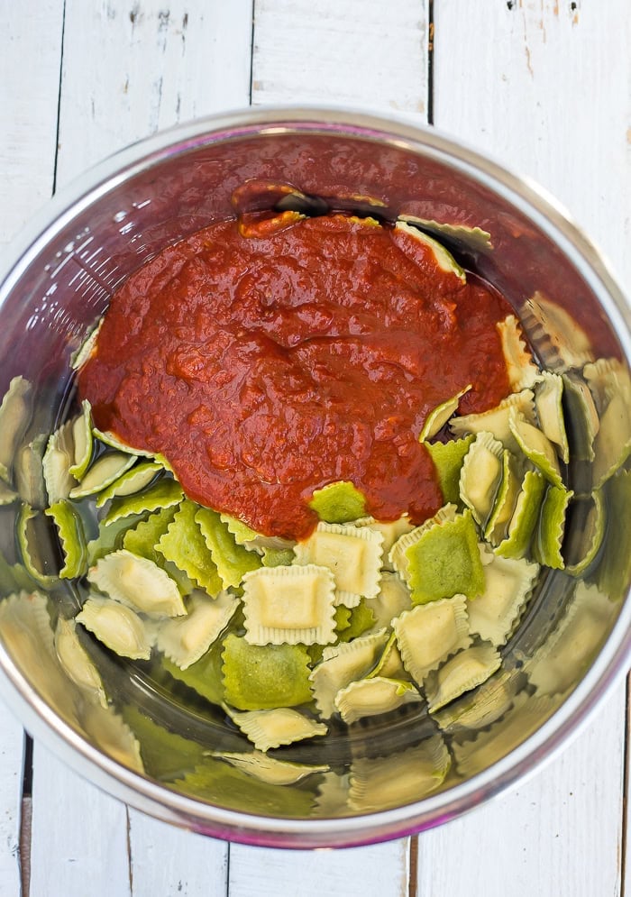 colorful pasta and marinara in a stainless steel pot.