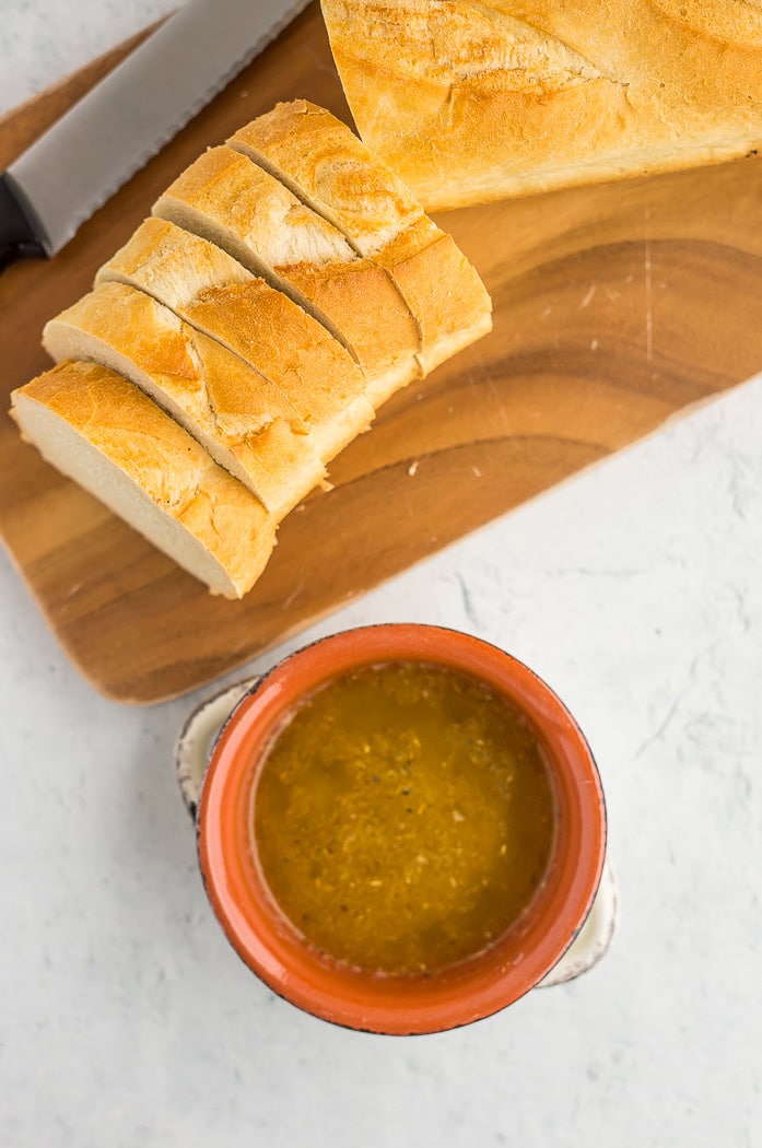 slices of bread and a bowl of butter sauce.