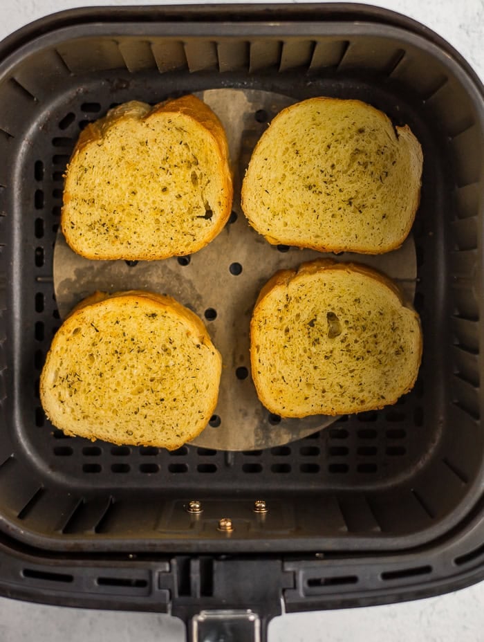 slices of garlic bread in an air fryer.