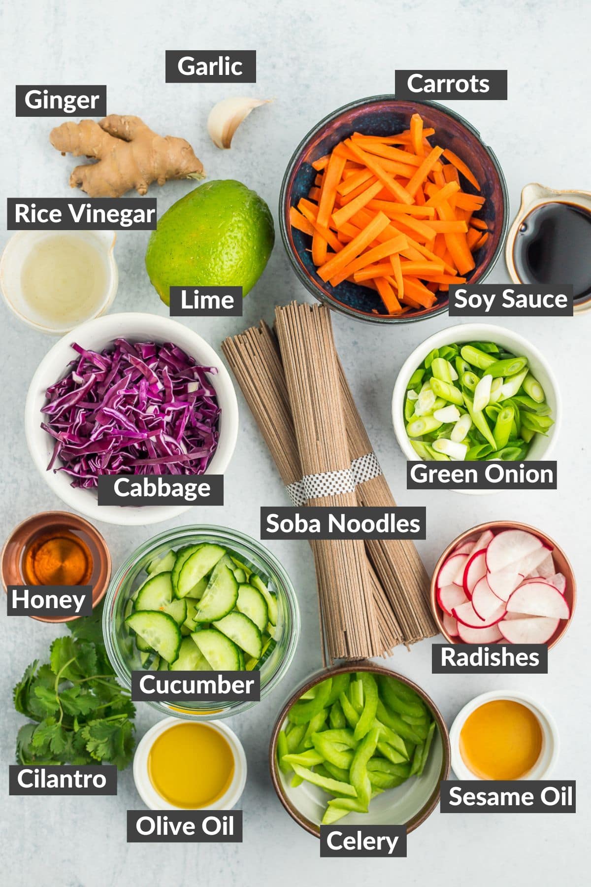colorful prepped vegetables in bowls along with ingredients such as ginger and lime.