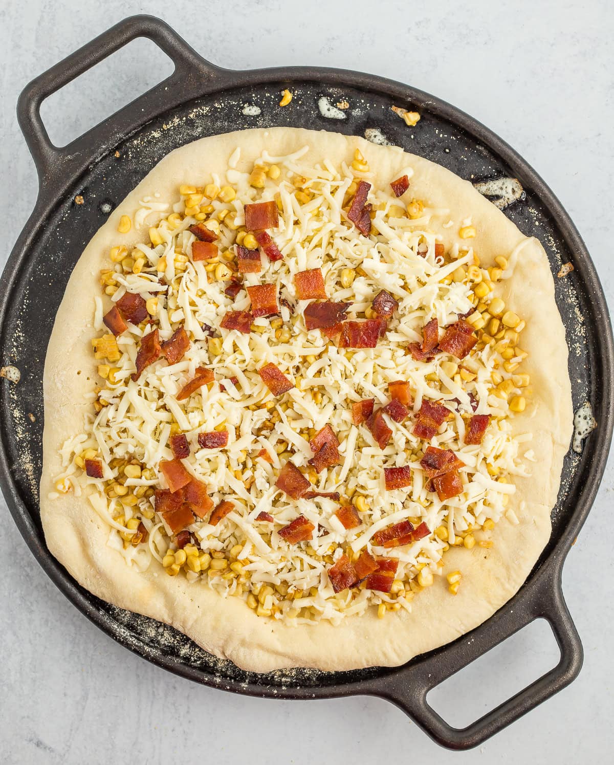 an unbaked pizza on a pizza stone.