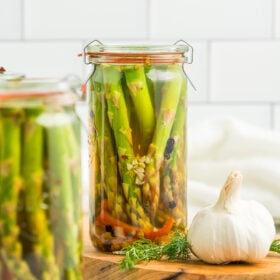 glass jars of fridge pickles on a wooden board.