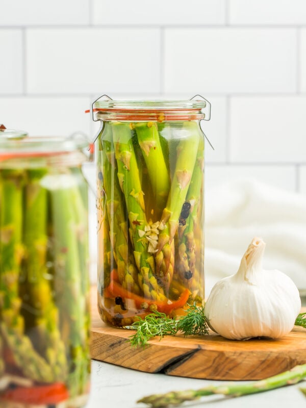 glass jars of fridge pickles on a wooden board.