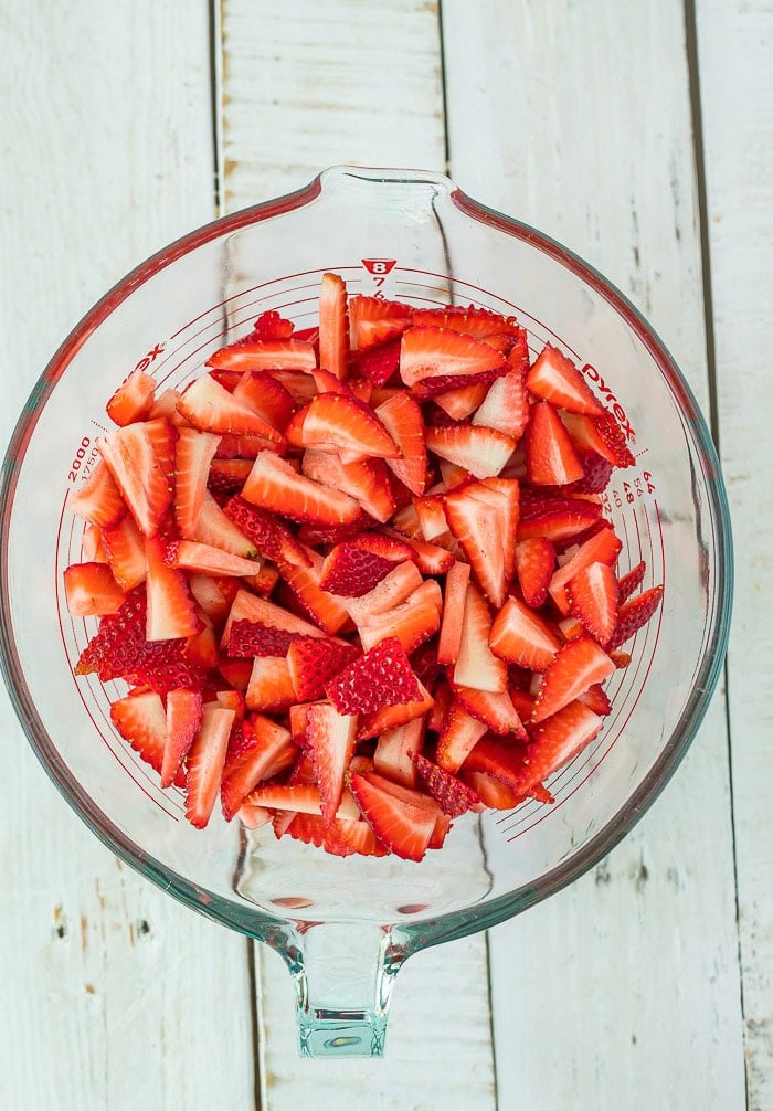 Sliced berries in a glass bowl.