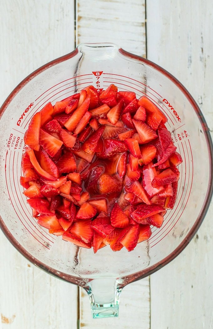 sliced strawberries in a glass bowl.