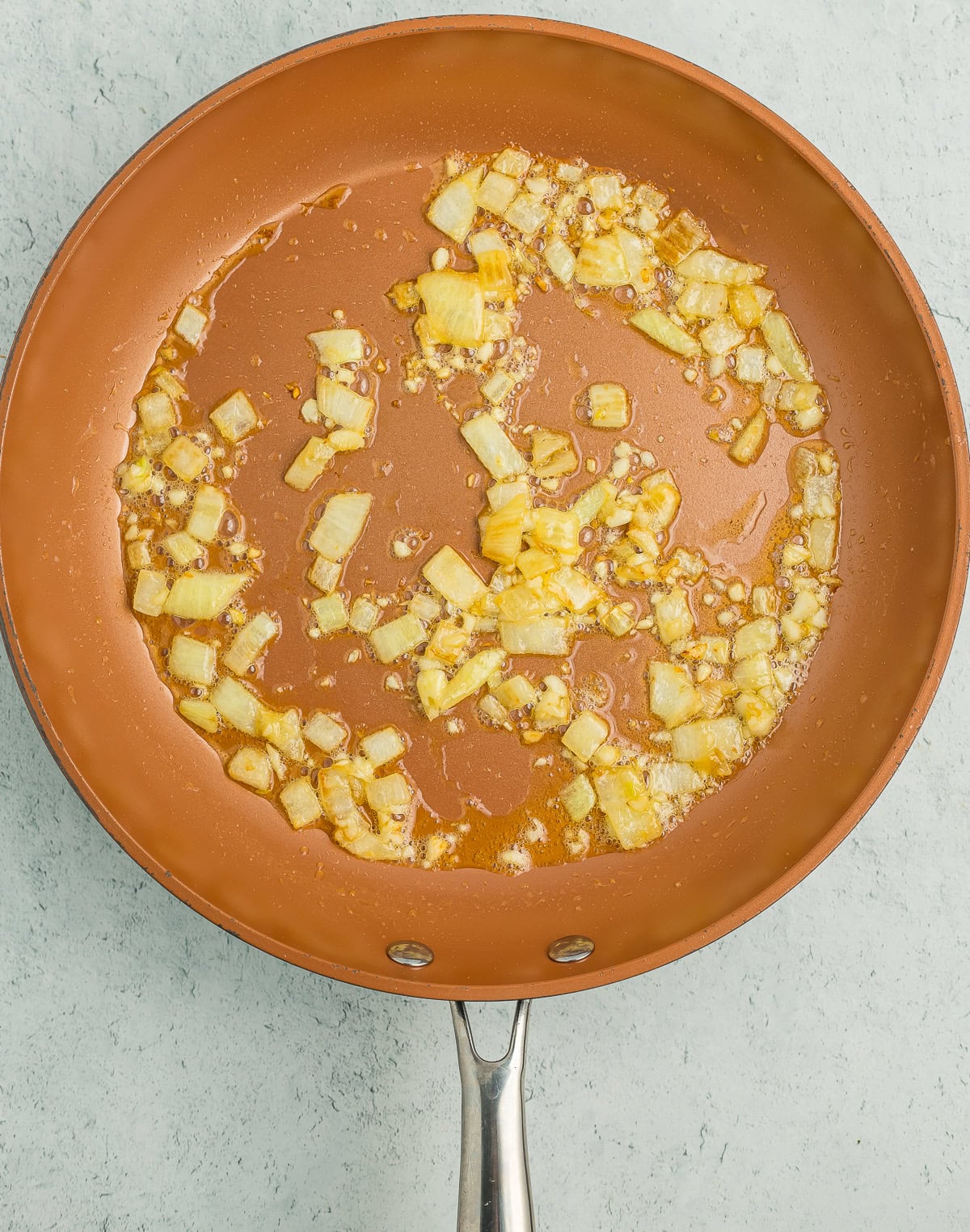 a frying pan with butter and onions.