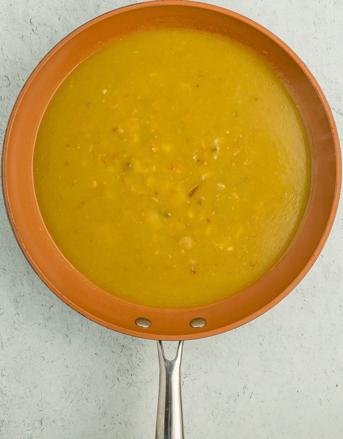 a frying pan with green sauce.