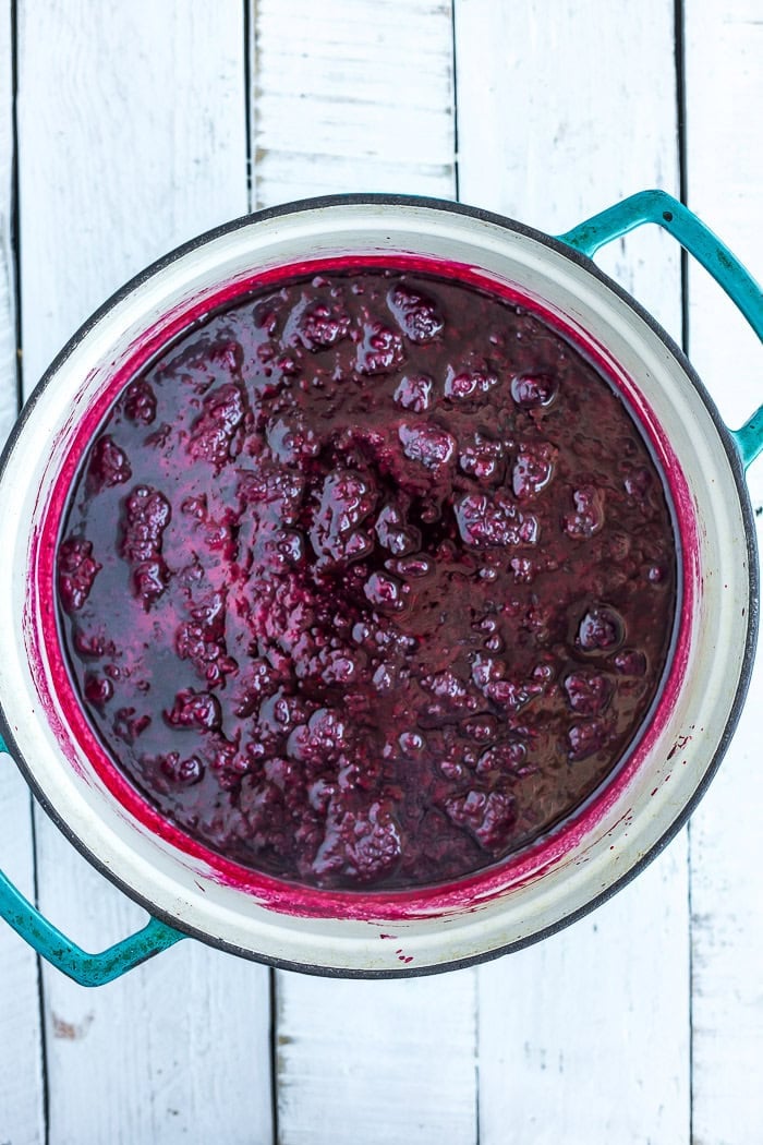 berries sauced in a teal Dutch oven.