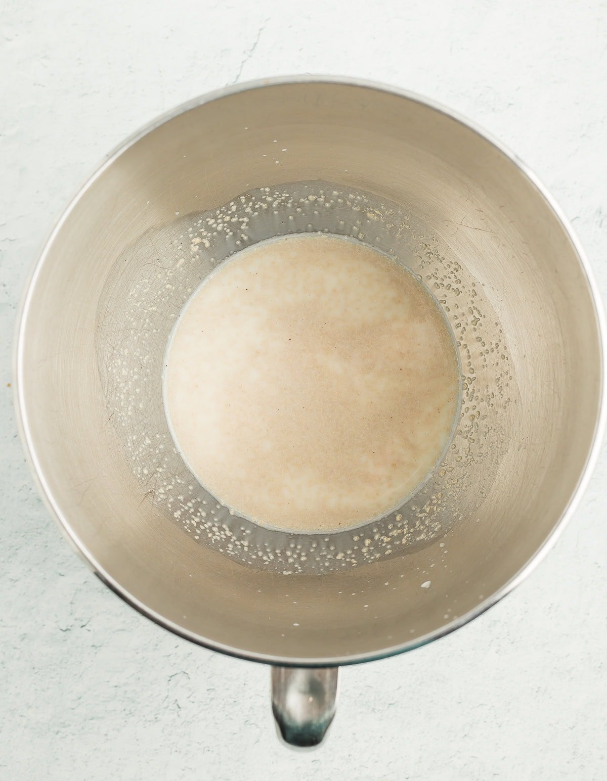 yeast and milk in a mixing bowl.