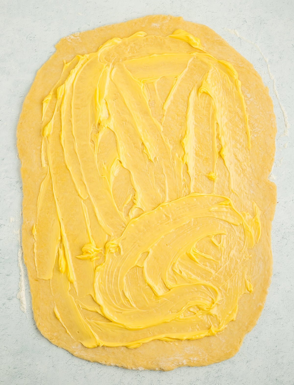 rolled dough with butter spread over it.