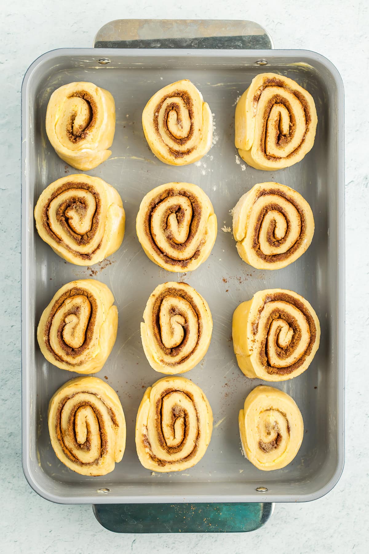 unbaked cinnamon rolls in a pan.