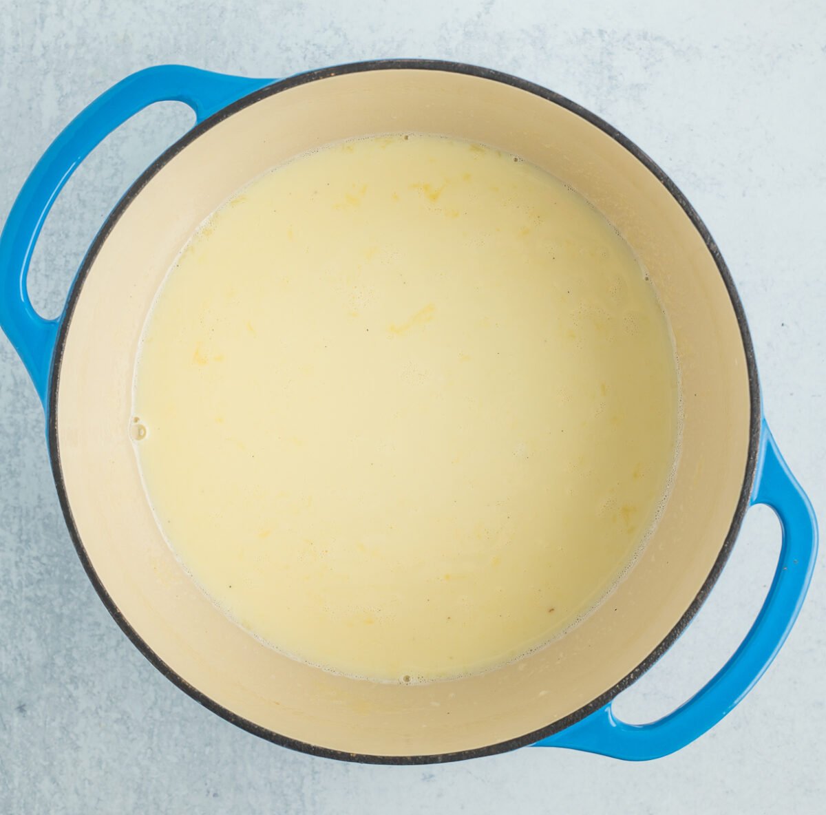a blue Dutch oven filled with dairy.