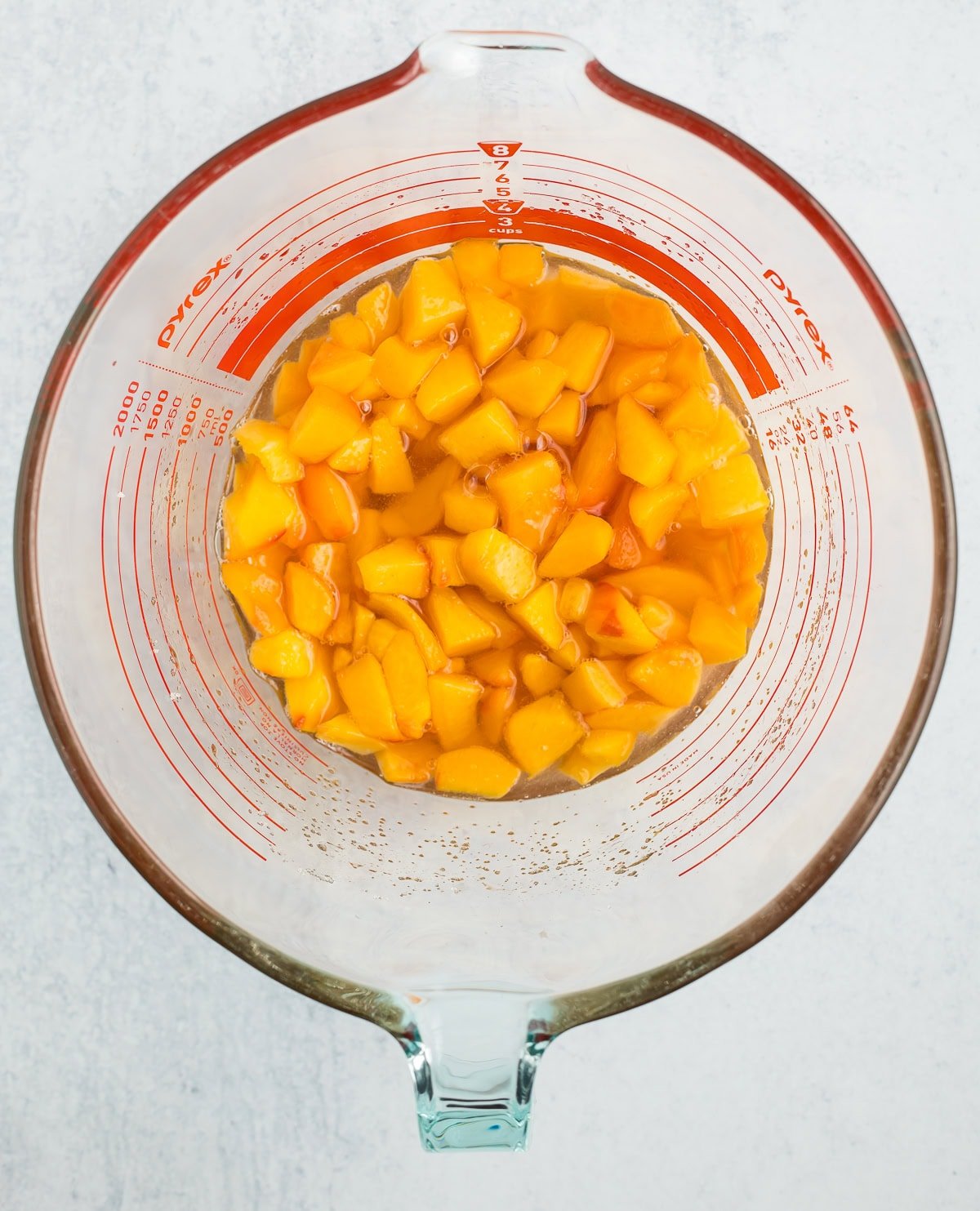 chopped peaches in a glass bowl.
