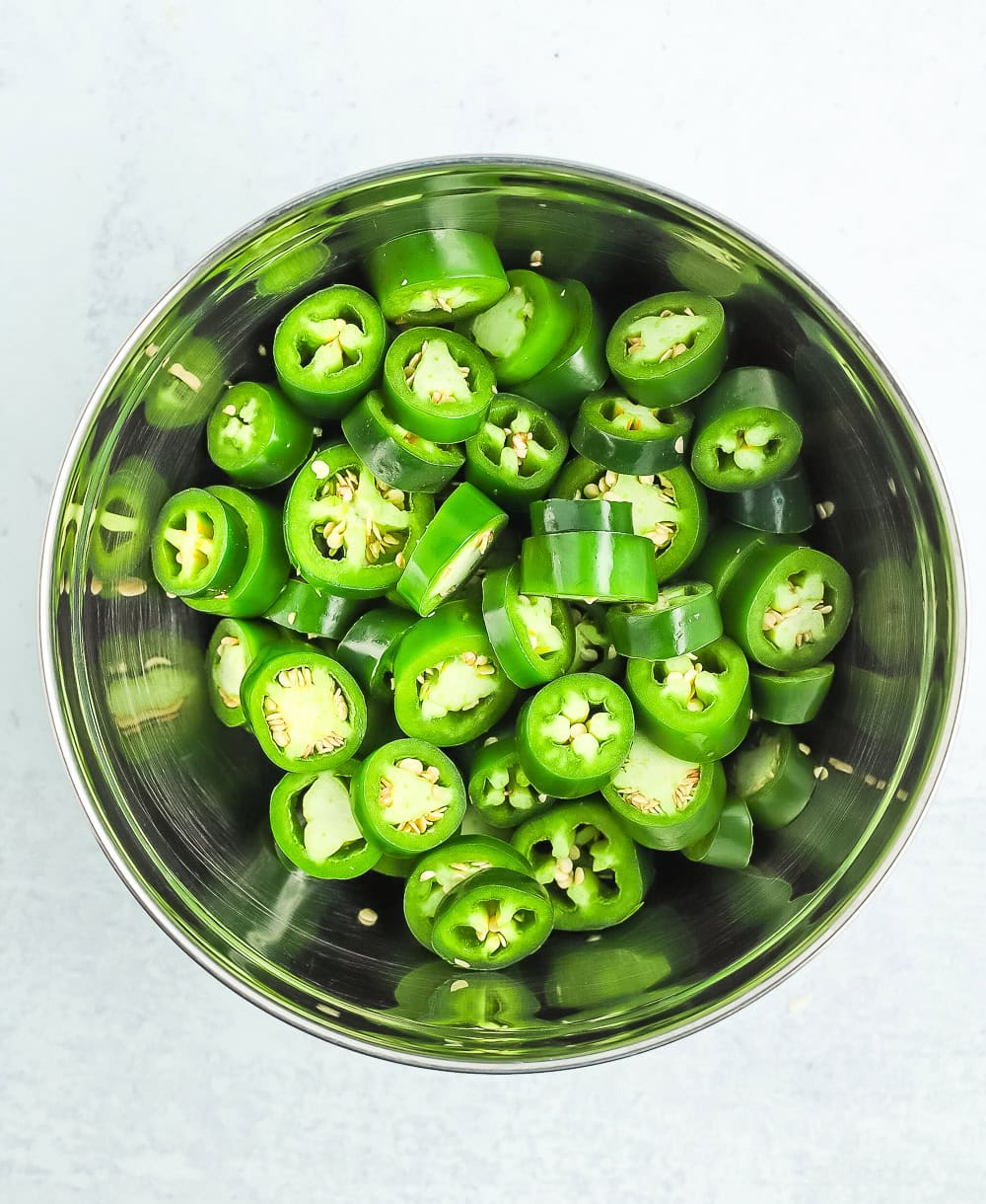 sliced jalapeños in a stainless bowl.