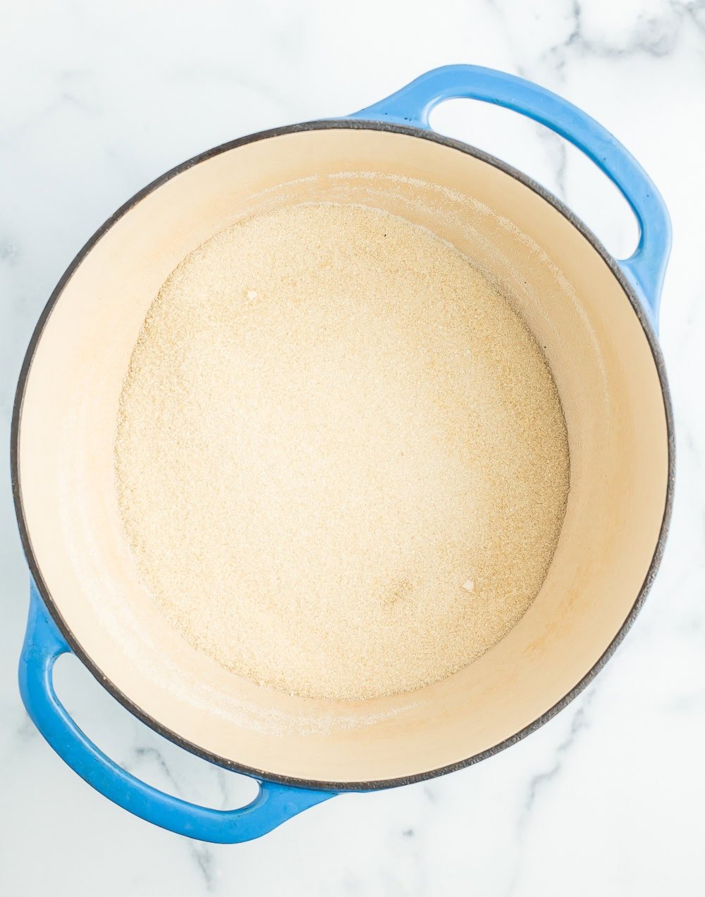 a blue Dutch oven with sugar.