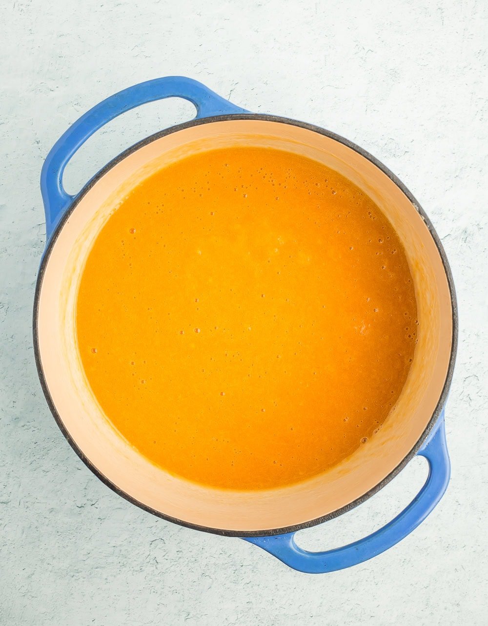 fruit sauce in a blue Dutch oven.