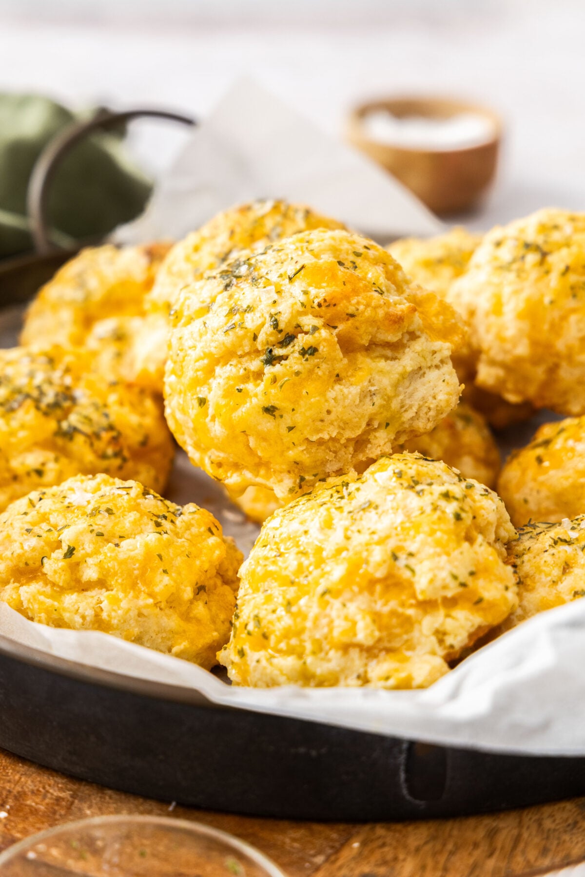 a side profile of Red Lobster biscuits topped with melted butter and dried parsley.