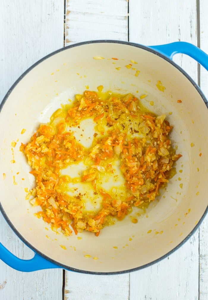 sauteed ingredients in a blue Dutch oven.