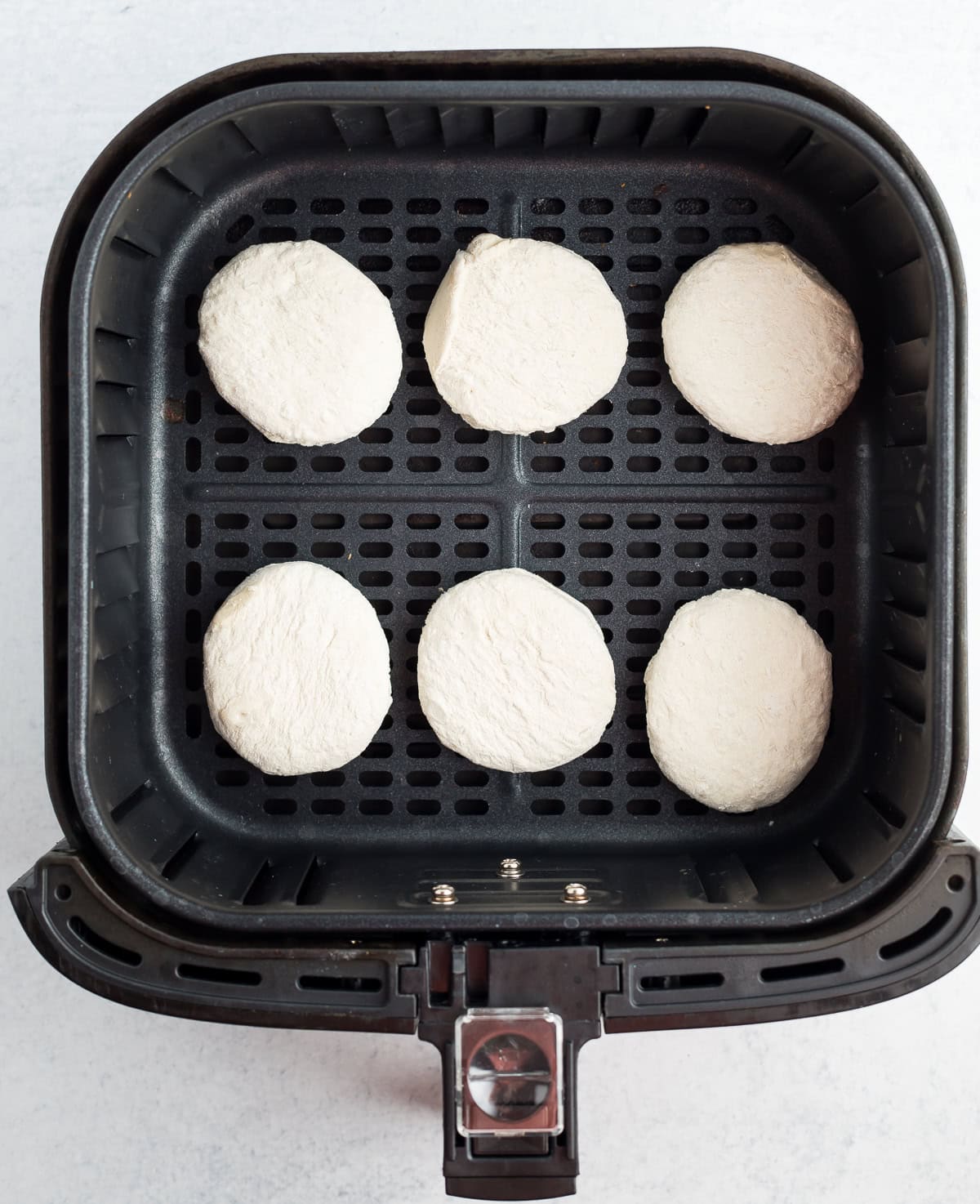 6 uncooked rolls in an air fryer.