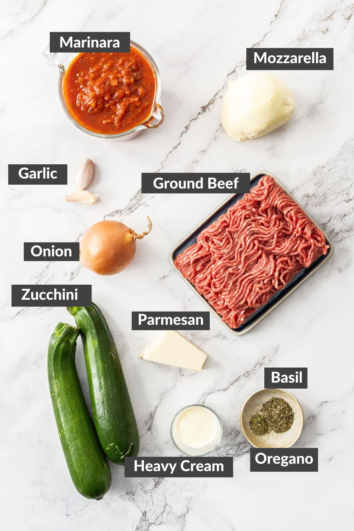 ground chuck, marinara, squash, and other ingredients on a marbled board.