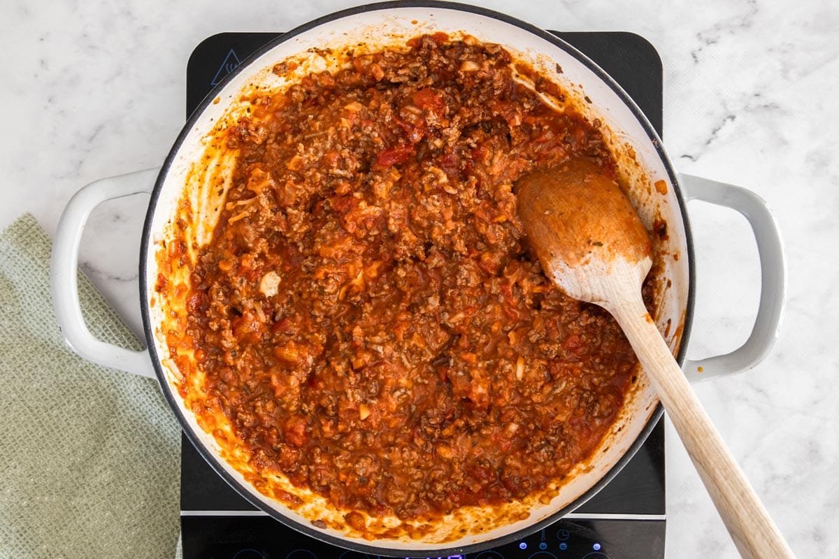 marinara and other ingredients in a white skillet.