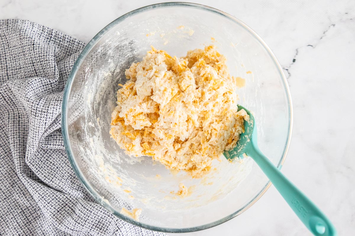 dough with shredded cheese in a glass bowl.
