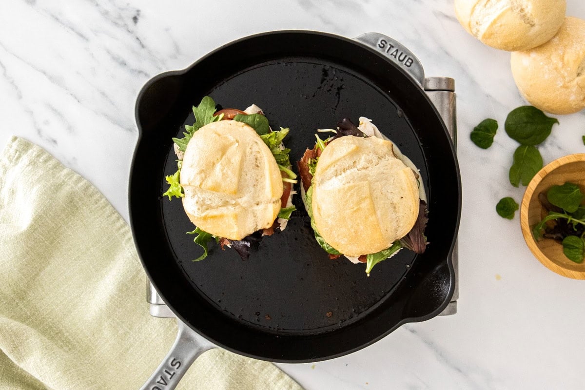 sandwiches toasting in a cast iron skillet.